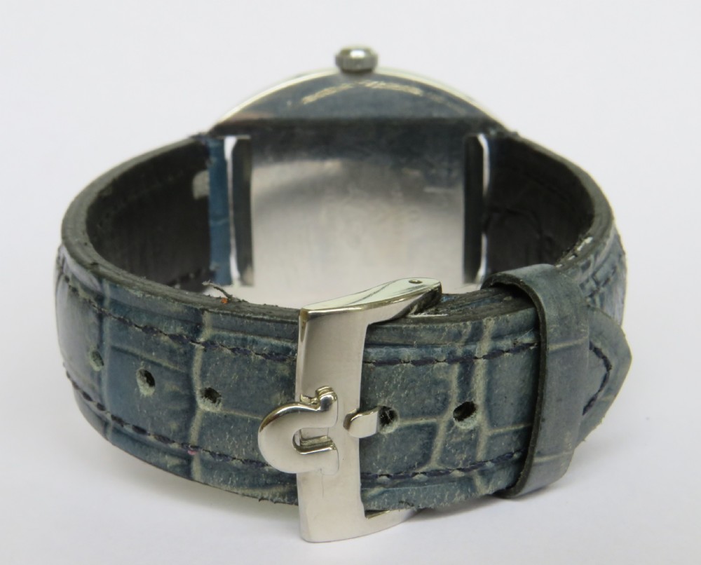 A 1960s gents Omega Seamaster Cosmic wristwatch featuring a stainless steel cushion case, silver dial with date display, and a blue leather strap. View IV