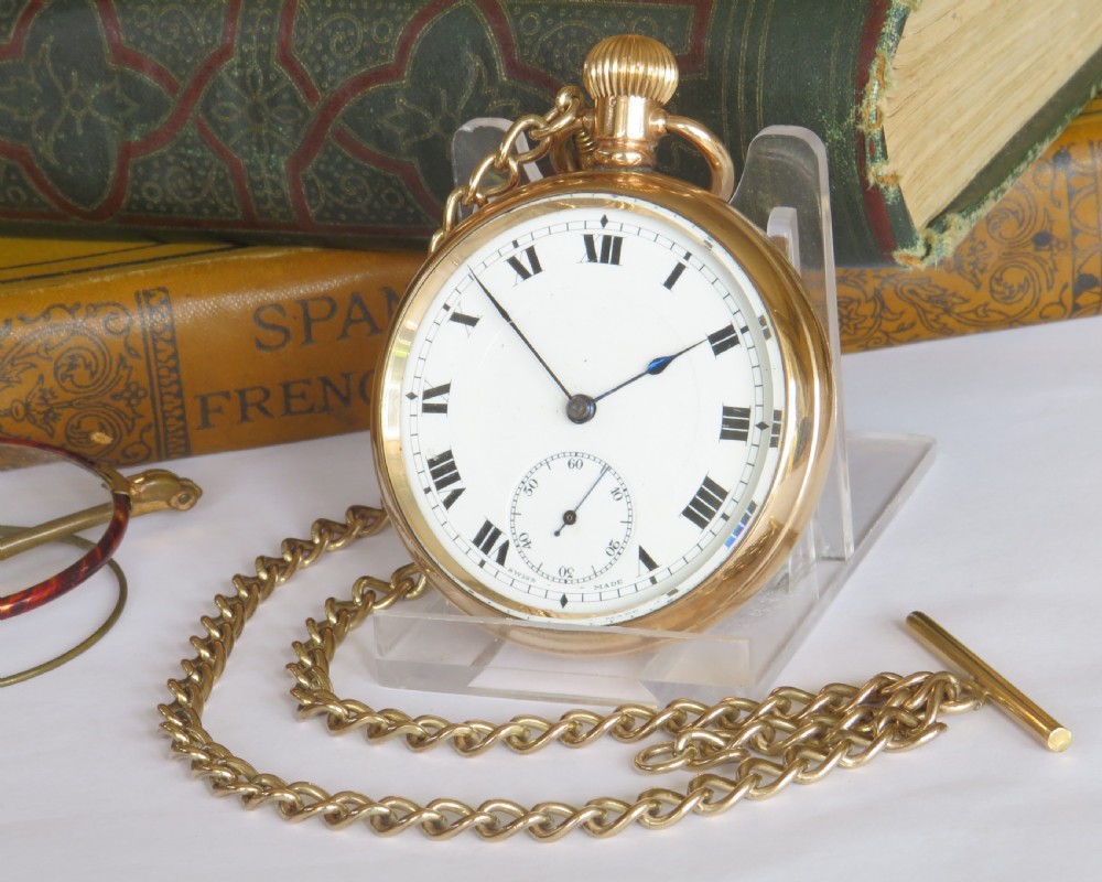 An antique gold-toned open-face pocket watch featuring a white enamel dial with black Roman numerals, blued steel hands, a subsidiary seconds dial, and an attached gold-toned Albert chain.