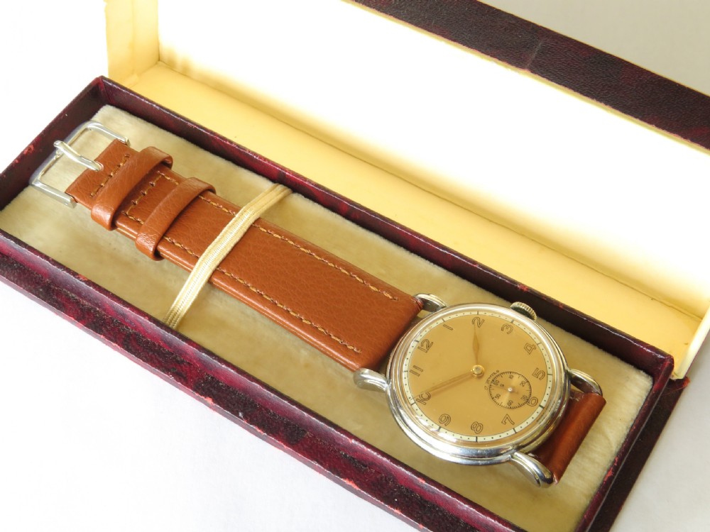A 1950s Swiss gents wristwatch featuring a champagne dial, Arabic numerals, sub-seconds dial at six oclock, and a tan leather strap. View II