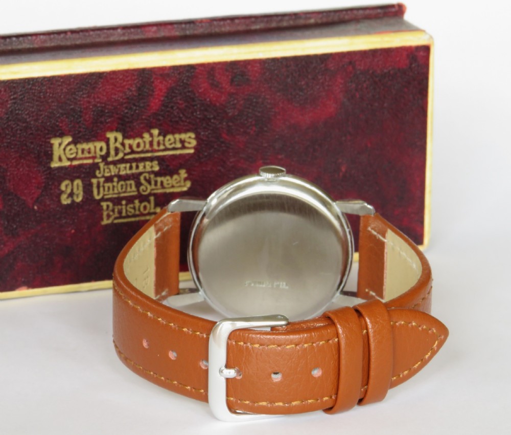 A 1950s Swiss gents wristwatch featuring a champagne dial, Arabic numerals, sub-seconds dial at six oclock, and a tan leather strap. View V