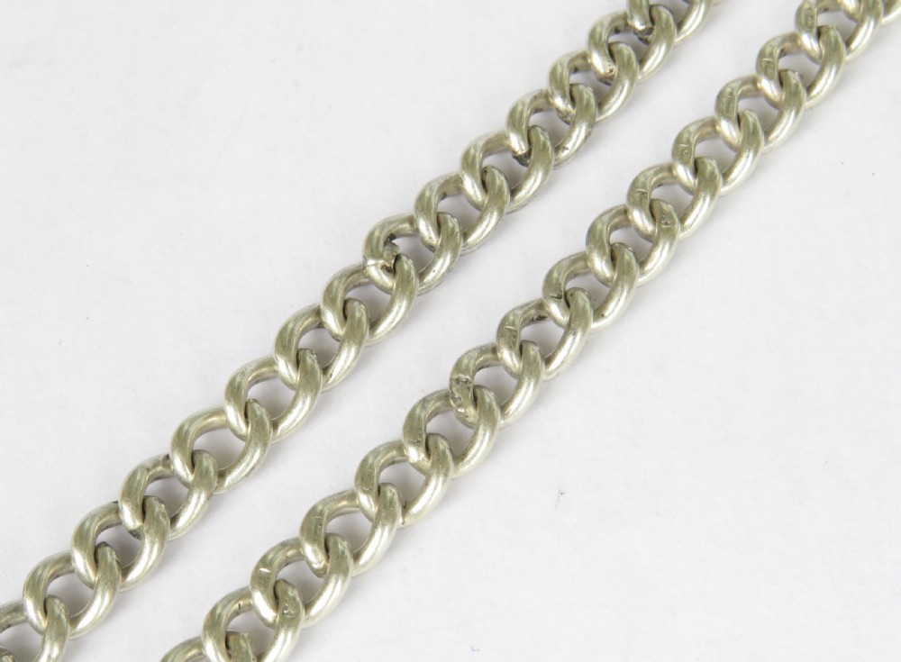 An antique sterling silver double Albert pocket watch chain featuring curb links, a T-bar, two swivel clasps, an engraved fob medal, and a fluted sovereign holder. View V