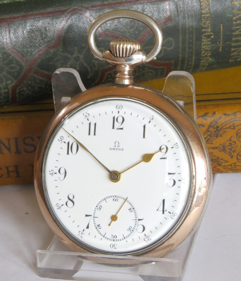 An antique open-face silver pocket watch featuring a white enamel dial with black Arabic numerals and a subsidiary seconds dial at six oclock.