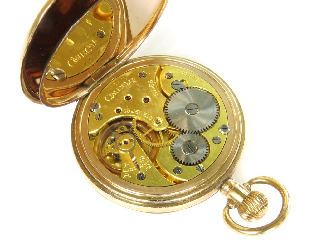 An open-face 1930s Omega gold pocket watch featuring a white dial with black Roman numerals, a subsidiary seconds dial, and a top winding crown ring. View IV