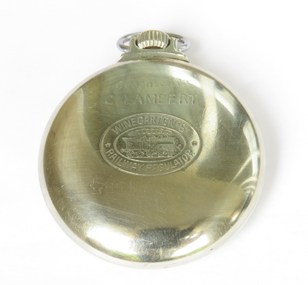 An open-face pocket watch featuring a white enamel dial with black Roman numerals, blued steel hands, a subsidiary seconds dial, and a silver-toned metal case with a gold-coloured winding crown. View IV