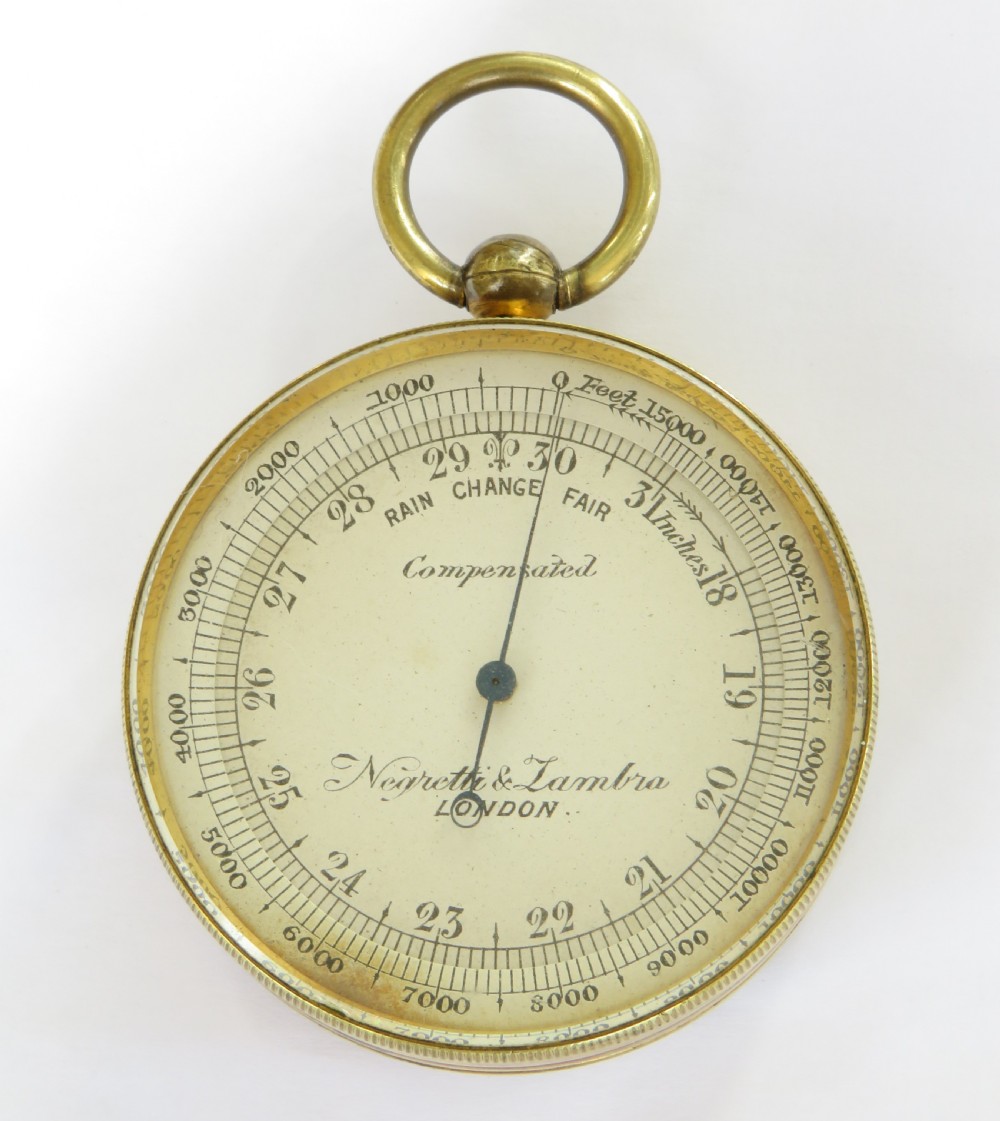 A Victorian brass pocket barometer by Negretti & Zambra featuring a calibrated white dial, central pointer, and top suspension ring. View III