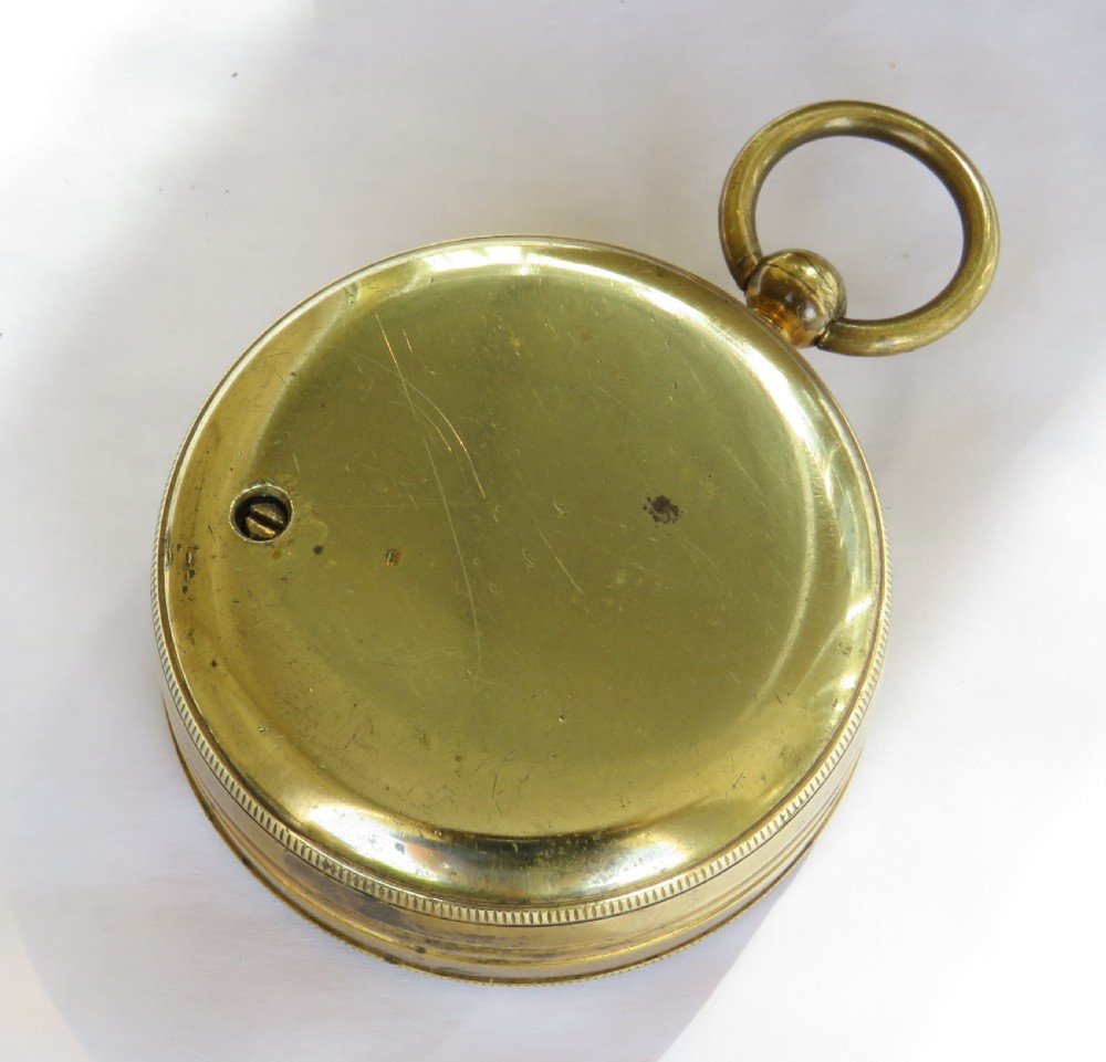 A Victorian brass pocket barometer by Negretti & Zambra featuring a calibrated white dial, central pointer, and top suspension ring. View IV