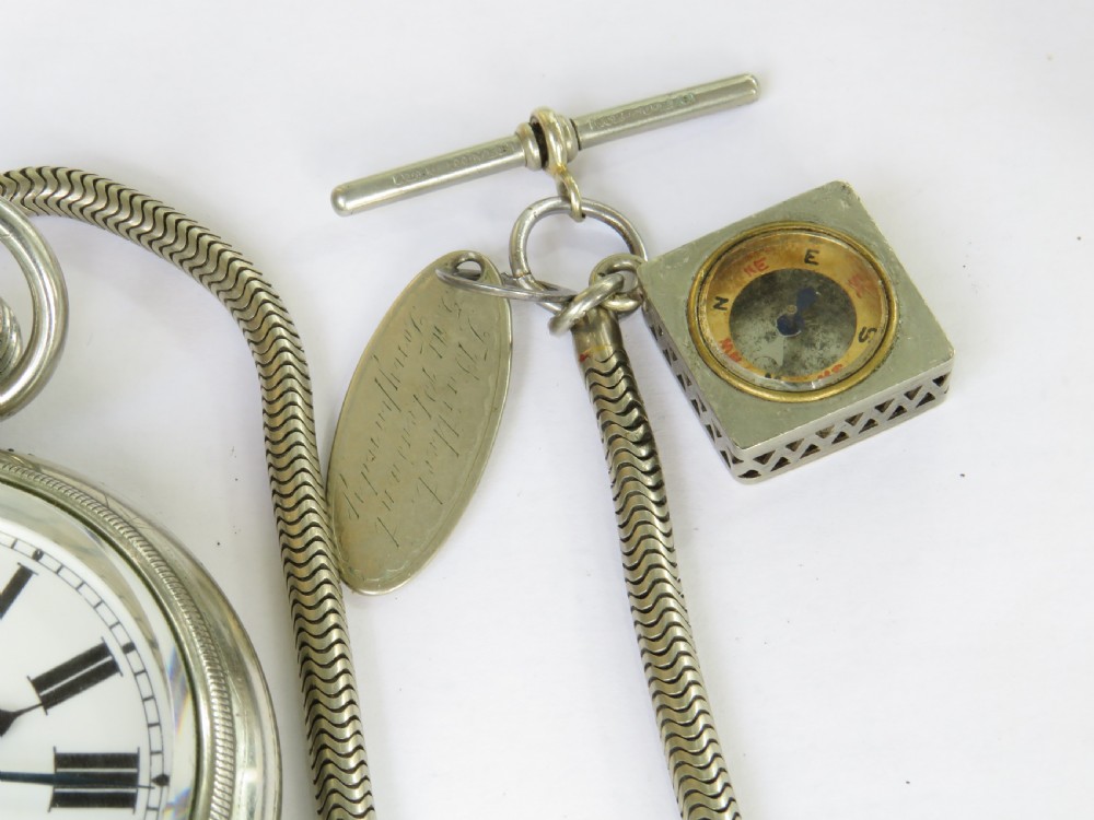 An open face 1930s silver pocket watch with Roman numerals and a subsidiary seconds dial, attached to a flexible snake chain Albert with a square compass fob. View V