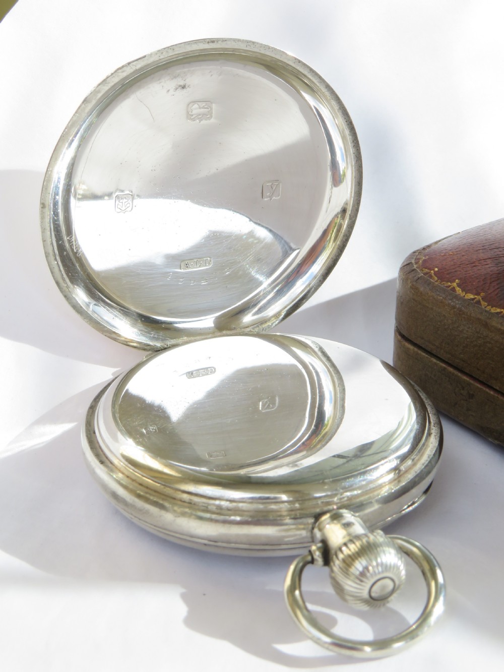 An antique open-face sterling silver pocket watch featuring a white enamel dial with black Arabic numerals and a subsidiary seconds dial. View III