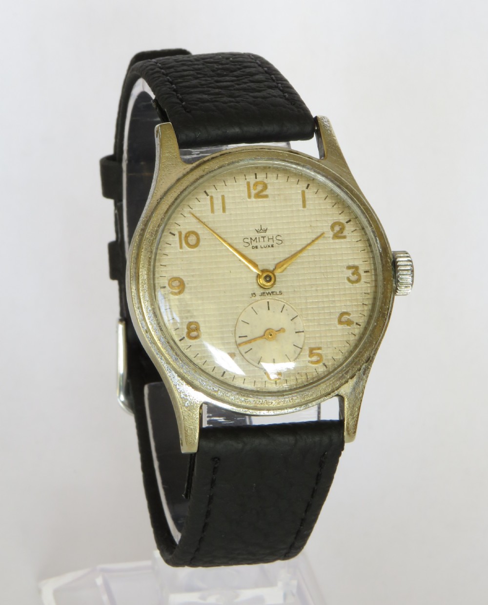 A 1950s Smiths De Luxe gents wristwatch featuring a textured cream dial with gold-tone Arabic numerals, sub-seconds dial, and a black leather strap. View II