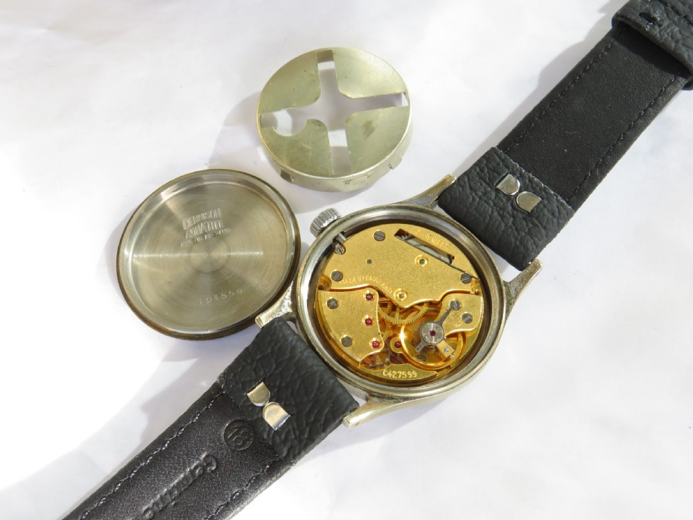 A 1950s Smiths De Luxe gents wristwatch featuring a textured cream dial with gold-tone Arabic numerals, sub-seconds dial, and a black leather strap. View III