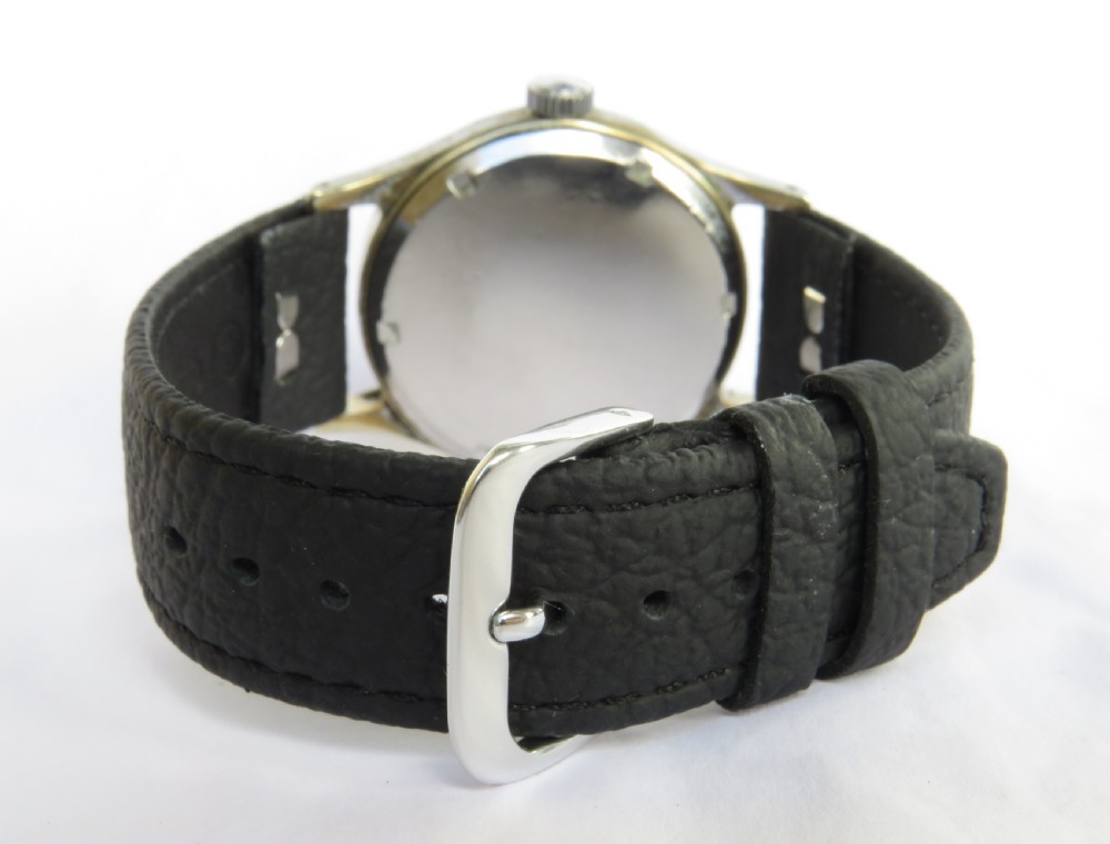 A 1950s Smiths De Luxe gents wristwatch featuring a textured cream dial with gold-tone Arabic numerals, sub-seconds dial, and a black leather strap. View IV