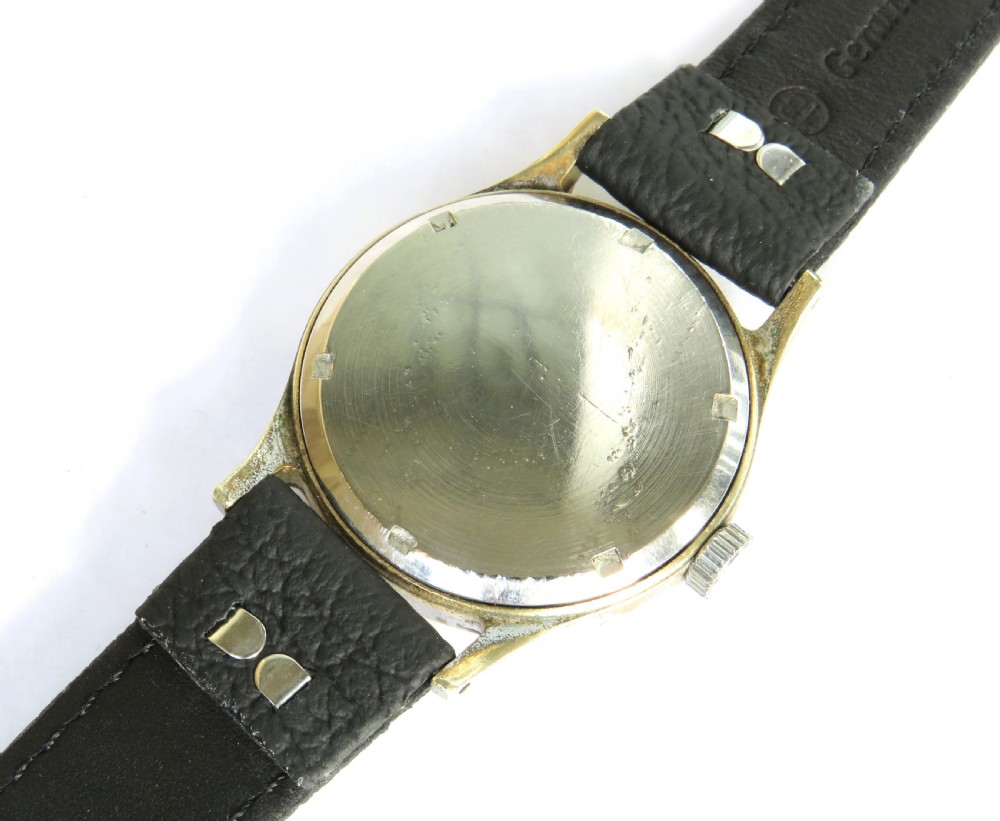A 1950s Smiths De Luxe gents wristwatch featuring a textured cream dial with gold-tone Arabic numerals, sub-seconds dial, and a black leather strap. View V