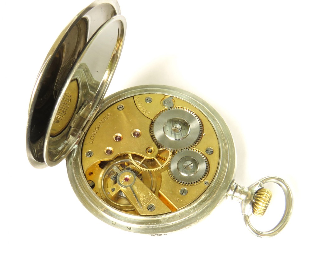 An antique open face Longines pocket watch featuring a white enamel dial with black Arabic numerals, a sub-seconds dial, and a silver casing with a brass crown. View IV