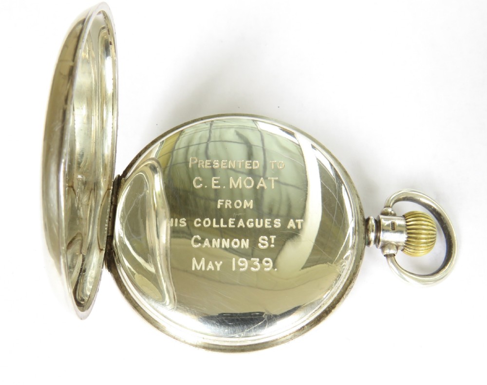 A 1930s open-face pocket watch featuring a silver case, white enamel dial with black Arabic numerals, and a subsidiary seconds dial at six oclock. View IV
