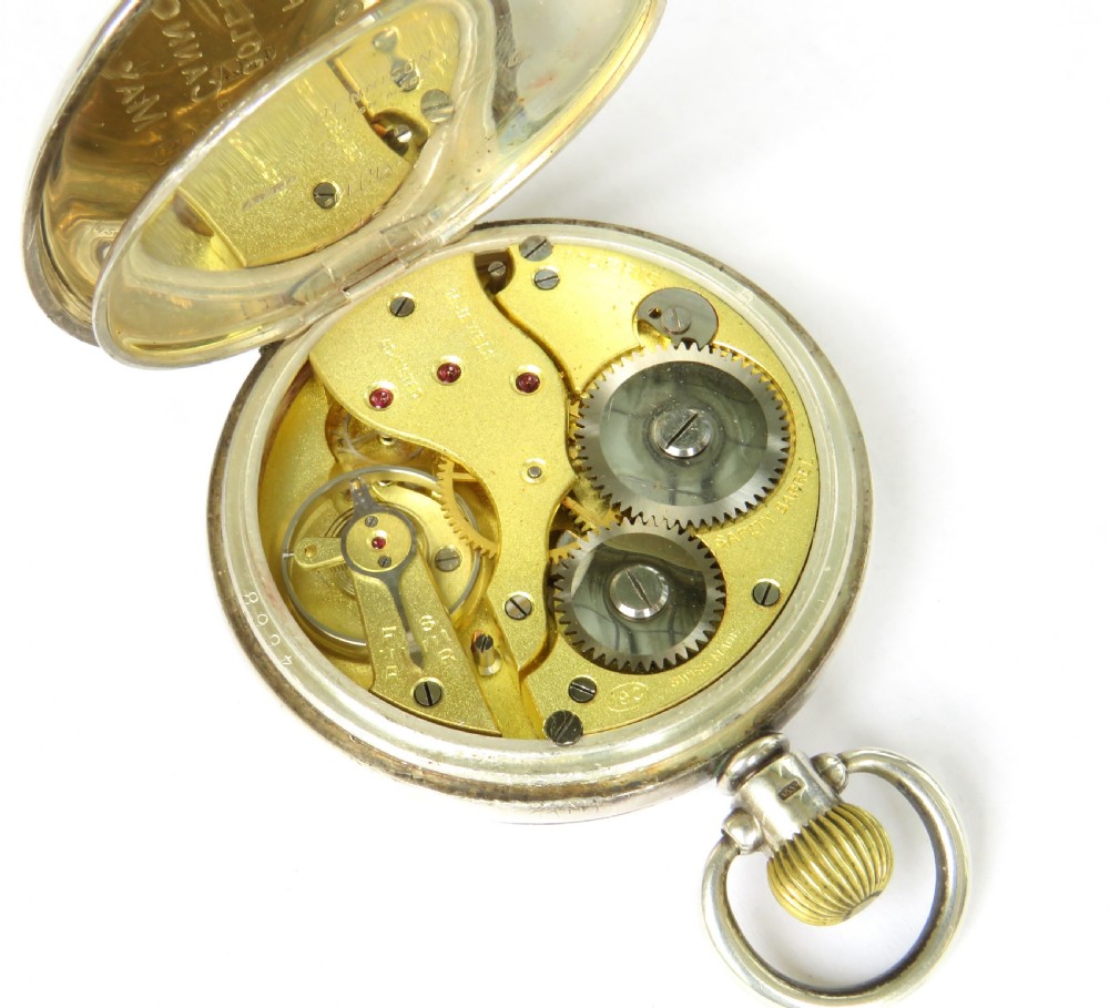 A 1930s open-face pocket watch featuring a silver case, white enamel dial with black Arabic numerals, and a subsidiary seconds dial at six oclock. View V
