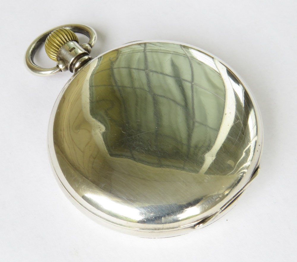 A 1930s open-face pocket watch featuring a silver case, white enamel dial with black Arabic numerals, and a subsidiary seconds dial at six oclock. View VI