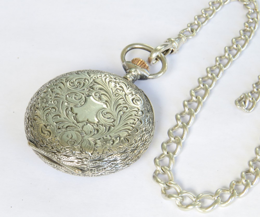 An antique sterling silver fob watch featuring an engraved case and white enamel dial alongside a silver curb-link Albert chain with a T-bar. View V
