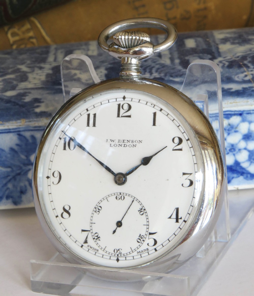 A 1940s silver-toned open-face pocket watch featuring a white enamel dial signed J W Benson London with black Arabic numerals and a subsidiary seconds dial.