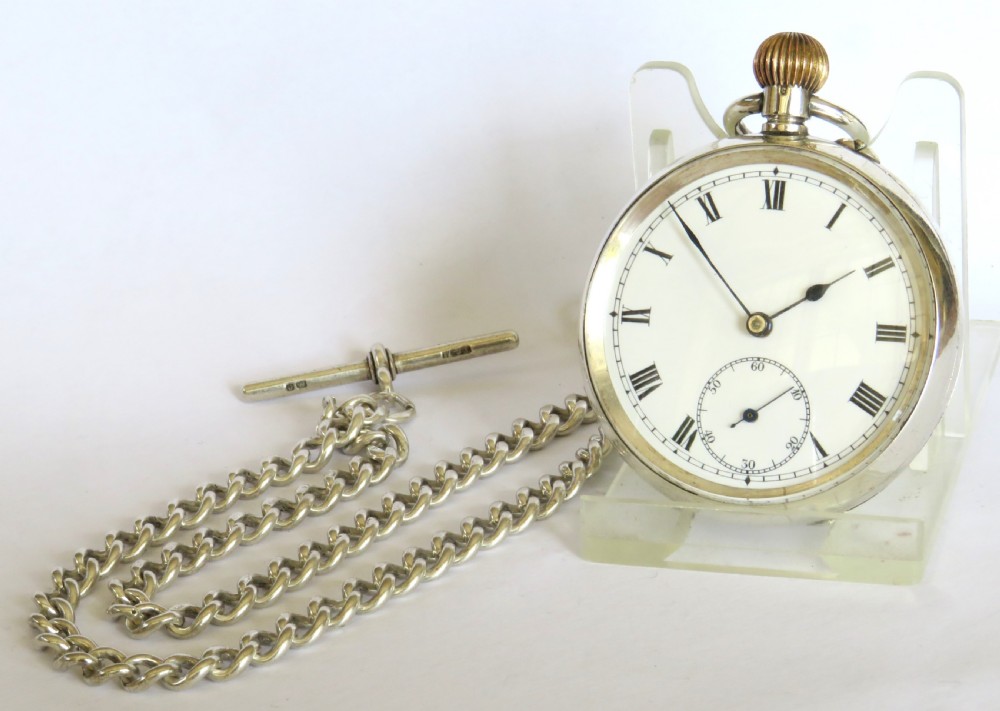 An antique Edwardian open-face silver pocket watch with a white enamel Roman numeral dial and an attached silver T-bar chain. View II