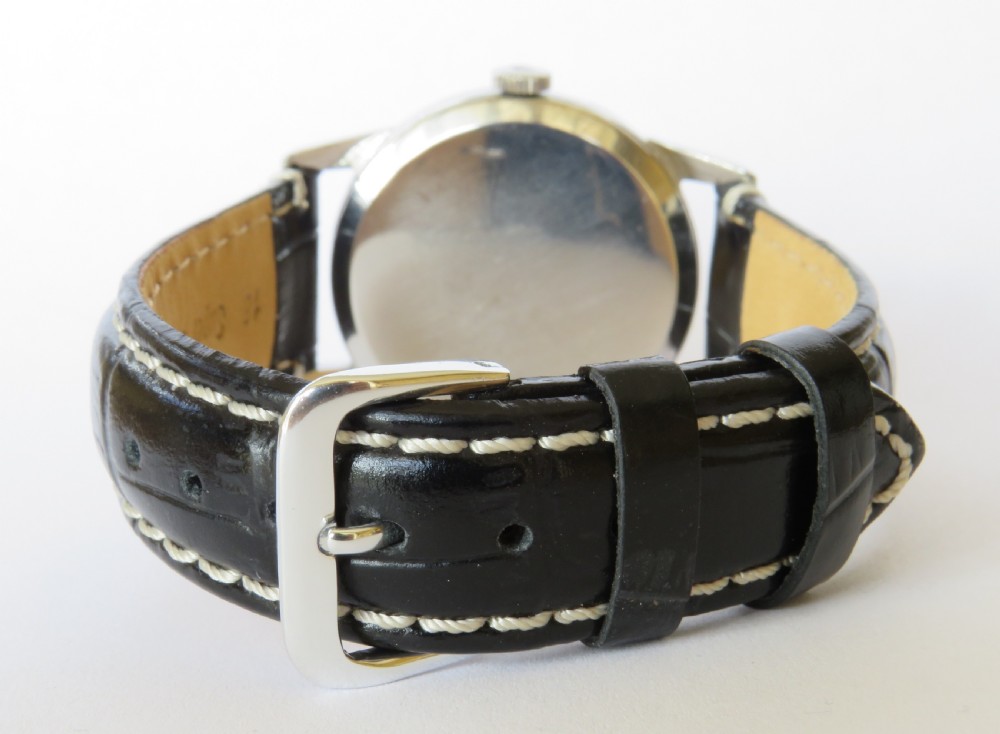 A 1960s gents Omega wristwatch with a round stainless steel case, a cream dial featuring baton markers and a sub-seconds dial, paired with a stitched black leather strap. View V