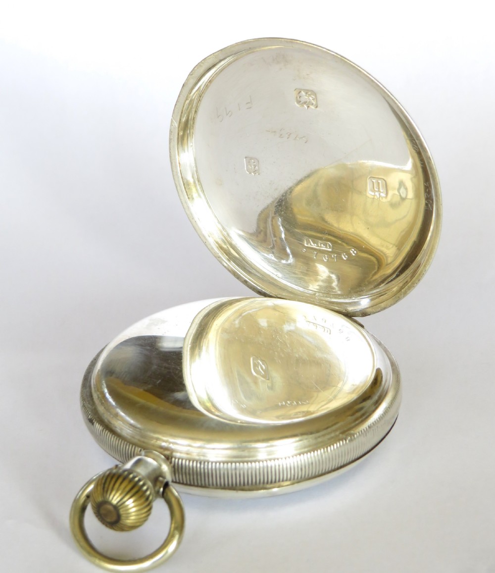 An open-face antique silver pocket watch featuring a white enamel dial, black Arabic numerals, and a subsidiary seconds dial at six oclock. View III