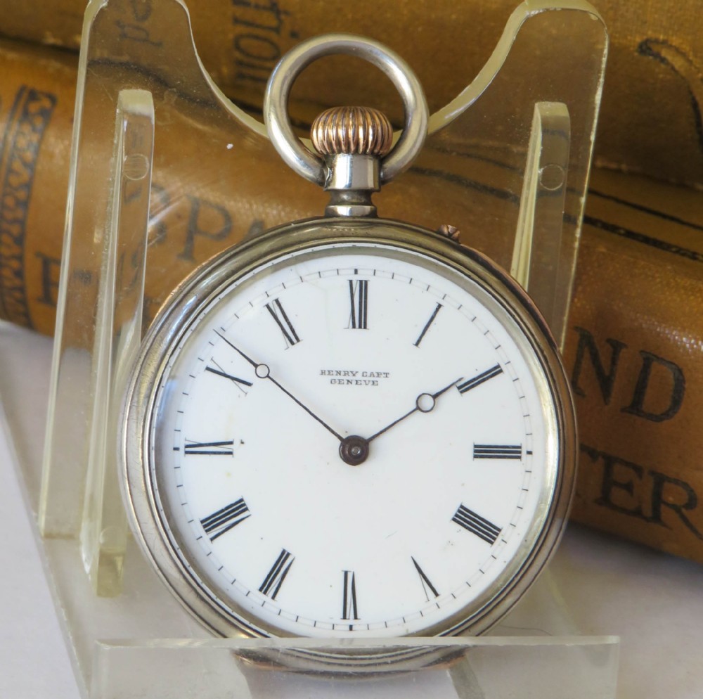 An antique Henry Capt silver open-face pocket watch featuring a white enamel dial with black Roman numerals and a rose gold winding crown.