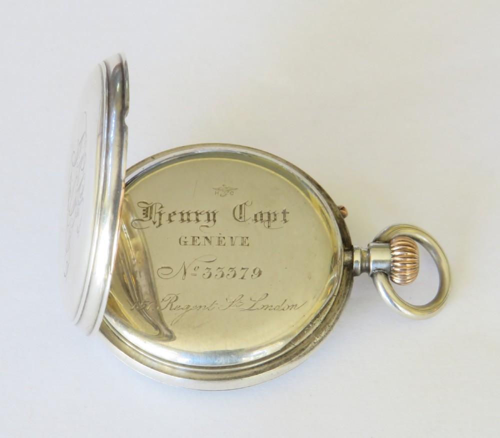 An antique Henry Capt silver open-face pocket watch featuring a white enamel dial with black Roman numerals and a rose gold winding crown. View III