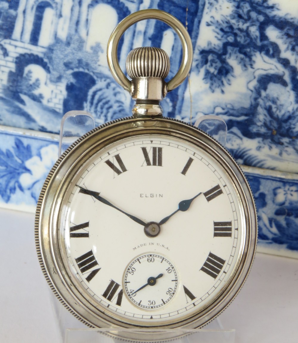An antique open-face silver pocket watch with a white dial featuring Roman numerals, spade hands, and a subsidiary seconds dial. View II