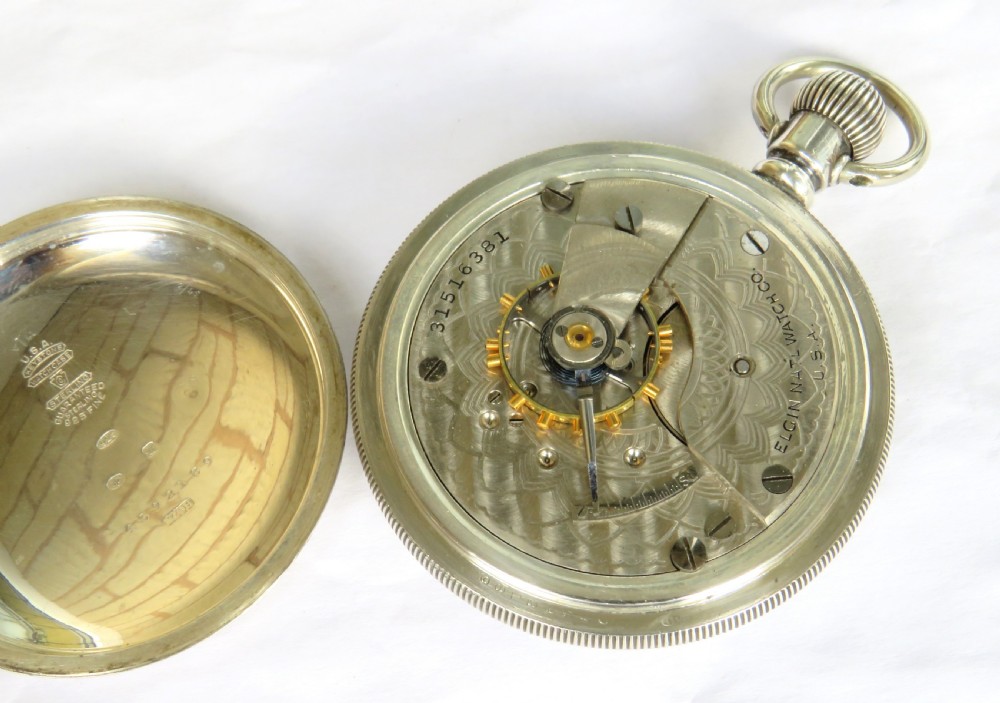 An antique open-face silver pocket watch with a white dial featuring Roman numerals, spade hands, and a subsidiary seconds dial. View III