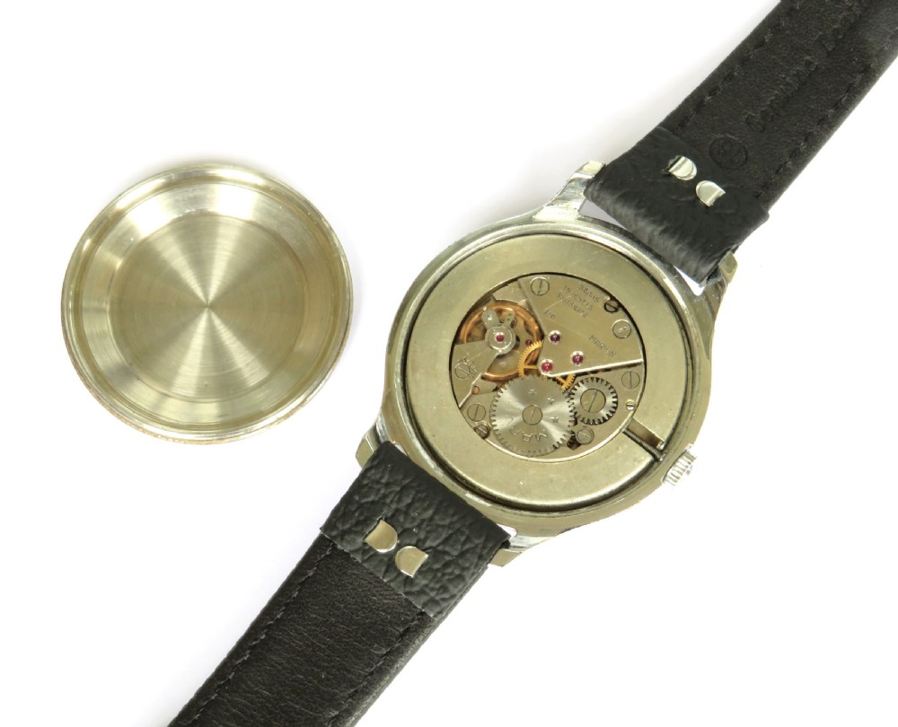 A 1950s gents Marvin wrist watch featuring a cream dial with Arabic numerals, a stainless steel case, and a textured black leather strap. View III