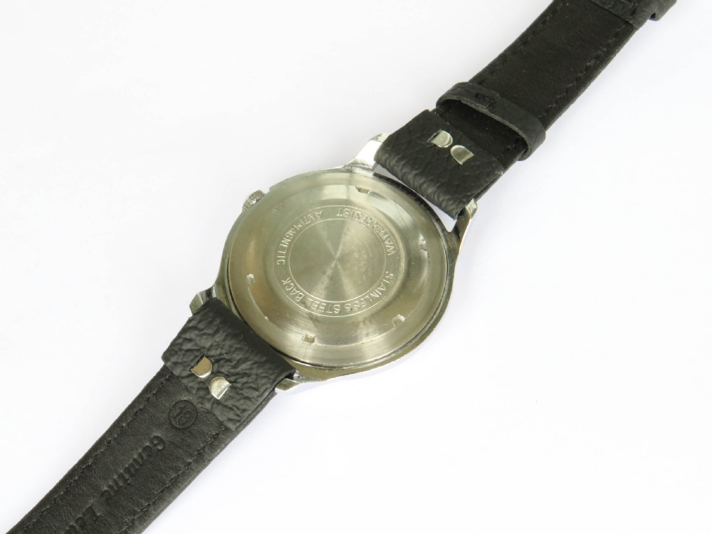 A 1950s gents Marvin wrist watch featuring a cream dial with Arabic numerals, a stainless steel case, and a textured black leather strap. View IV