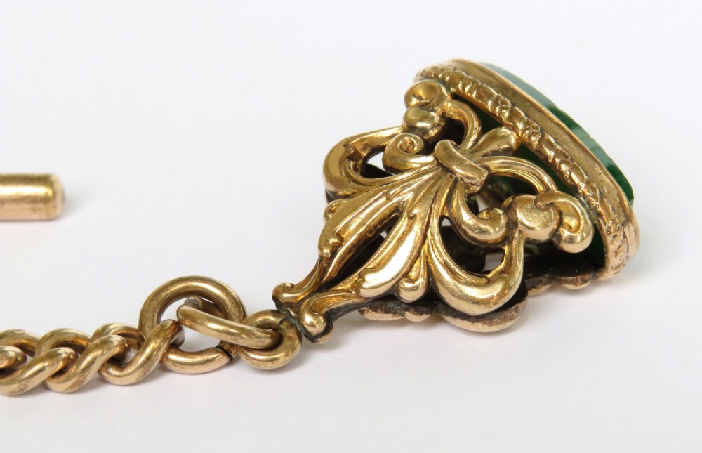An antique rolled gold curb link Albert watch chain featuring a T-bar, swivel clasp, bolt ring, and a suspended fob with a green oval stone intaglio. View III