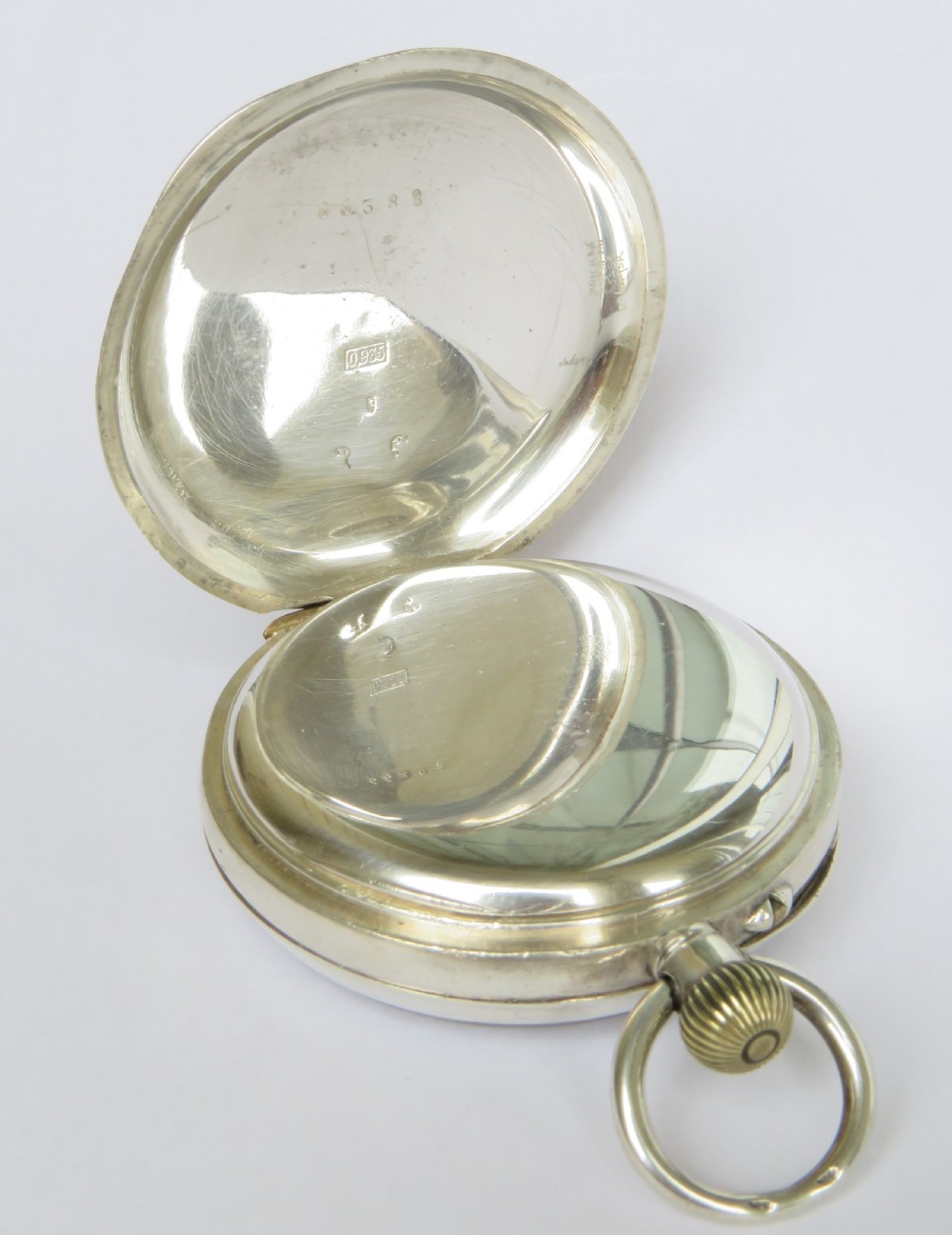 An open-face antique silver pocket watch featuring a white enamel dial with black Roman numerals and a subsidiary seconds dial. View III