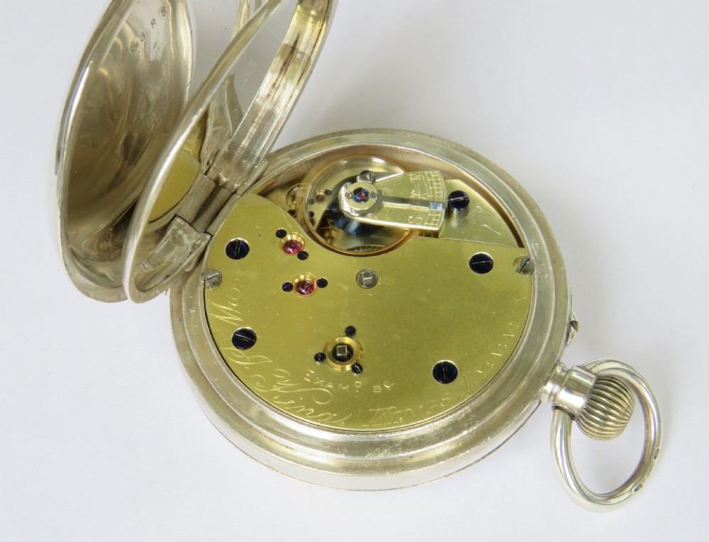 An open-face antique silver pocket watch featuring a white enamel dial with black Roman numerals and a subsidiary seconds dial. View IV