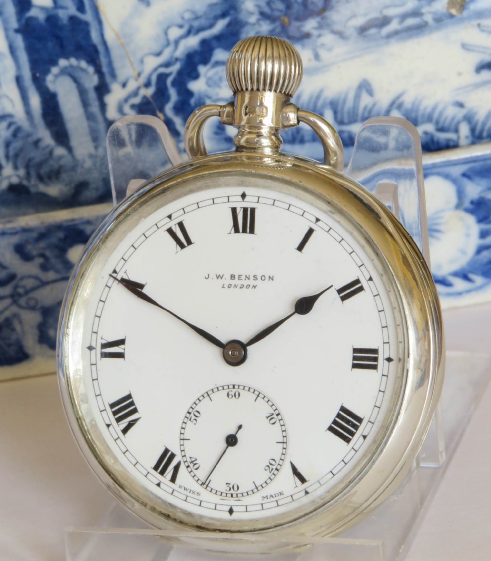 An open-face silver pocket watch by J.W. Benson featuring a white enamel dial with black Roman numerals and a subsidiary seconds dial.