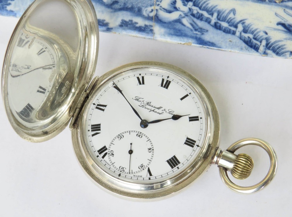 An open antique silver full hunter pocket watch displaying a white enamel dial with black Roman numerals and a subsidiary seconds dial. View II
