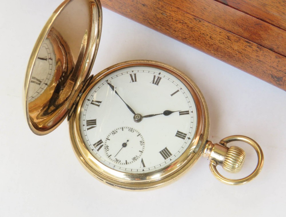 A 1930s gold full hunter pocket watch shown open to display a white enamel dial with Roman numerals and a subsidiary seconds dial. View II