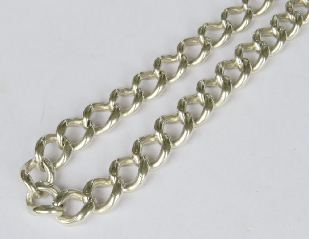 A Victorian sterling silver Albert pocket watch chain featuring graduated curb links, a T-bar, swivel clasp, and a shield fob with rose gold detailing. View IV