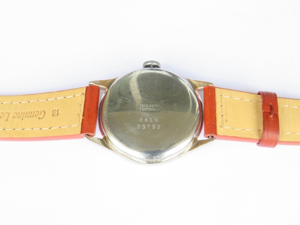 A 1950s Damas gents wrist watch featuring a cream dial with day, month, pointer date, and moonphase complications on a brown leather strap. View IV