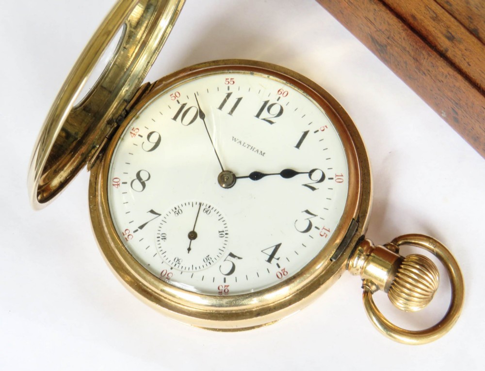 A gold-toned Waltham half hunter pocket watch with Roman numerals engraved around the central circular dial aperture. View III