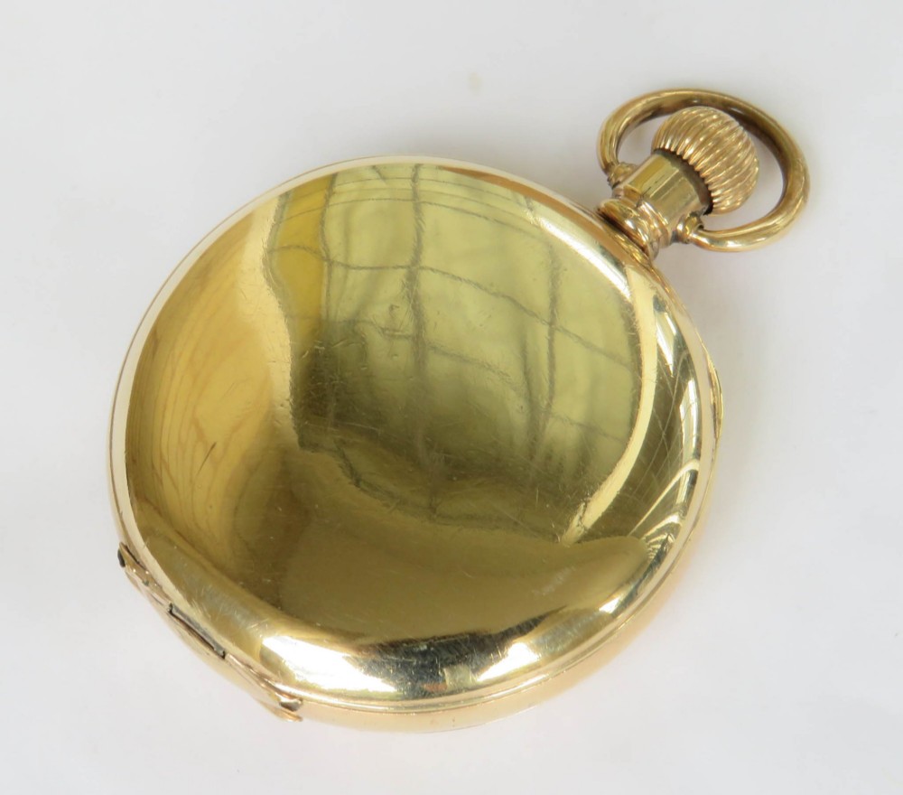 A gold-toned Waltham half hunter pocket watch with Roman numerals engraved around the central circular dial aperture. View VI