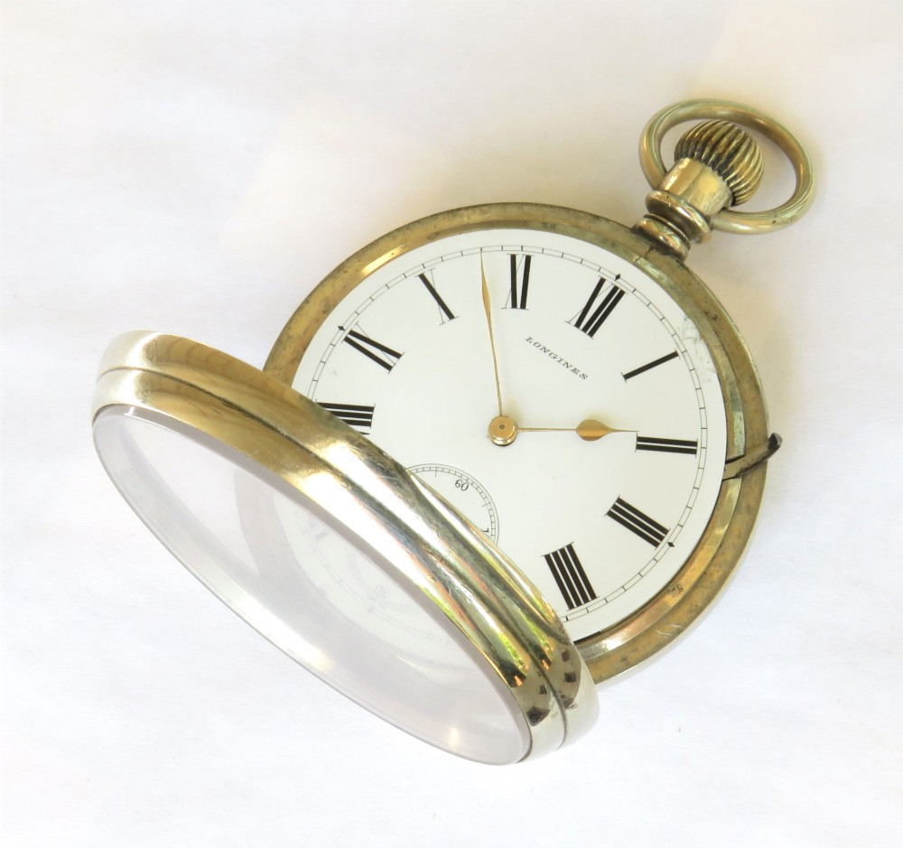 An antique open-face Longines pocket watch with a white enamel Roman numeral dial, connected to a silver-coloured curb chain with an enamelled fob medallion. View IV