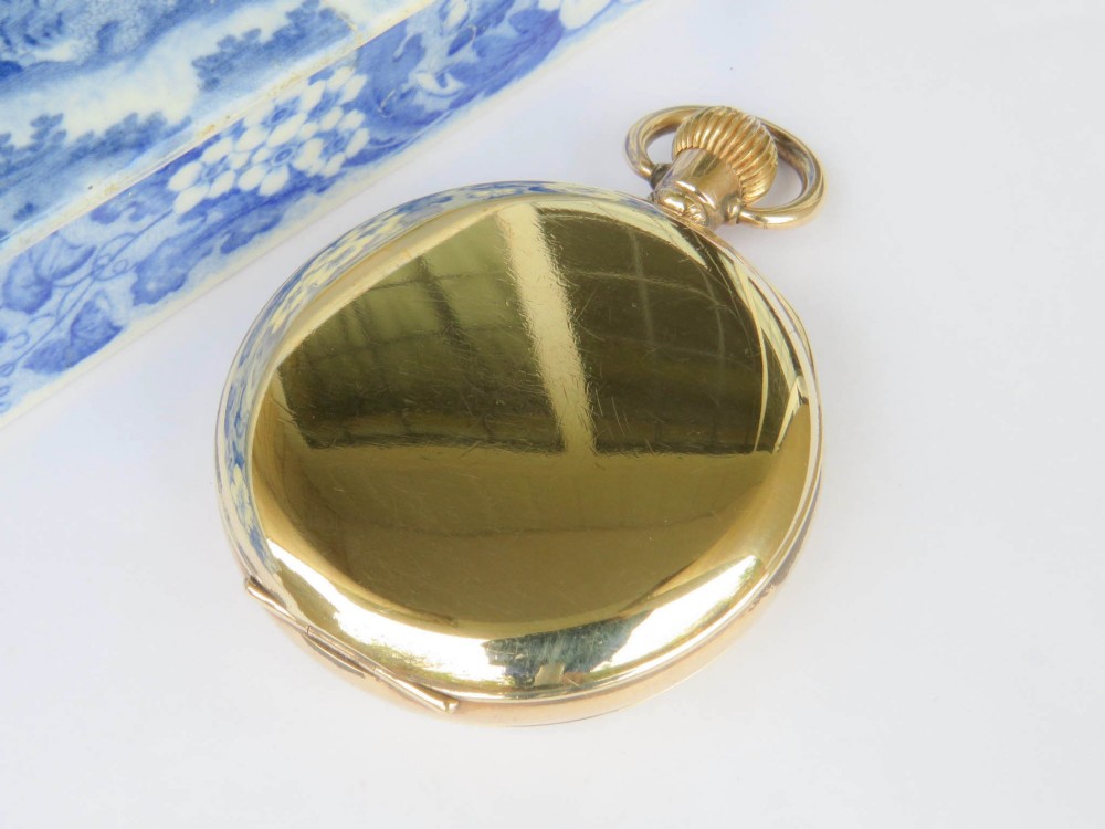 A gold-toned open-face Waltham pocket watch featuring a white enamel dial with black Roman numerals and a sub-seconds dial. View V