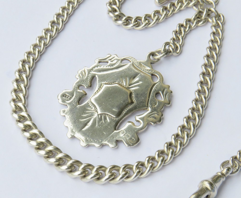 An antique sterling silver single Albert pocket watch chain with curb links, T-bar, swivel clasps, and a central shield-shaped fob. View II