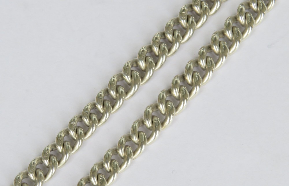 An antique sterling silver single Albert pocket watch chain with curb links, T-bar, swivel clasps, and a central shield-shaped fob. View IV