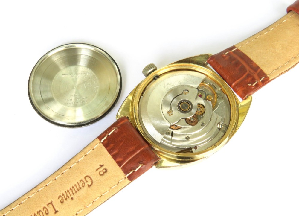 A 1969 gents Eterna-Matic 1000 wristwatch featuring a gold-toned cushion case, champagne dial with date aperture, and brown leather strap. View IV
