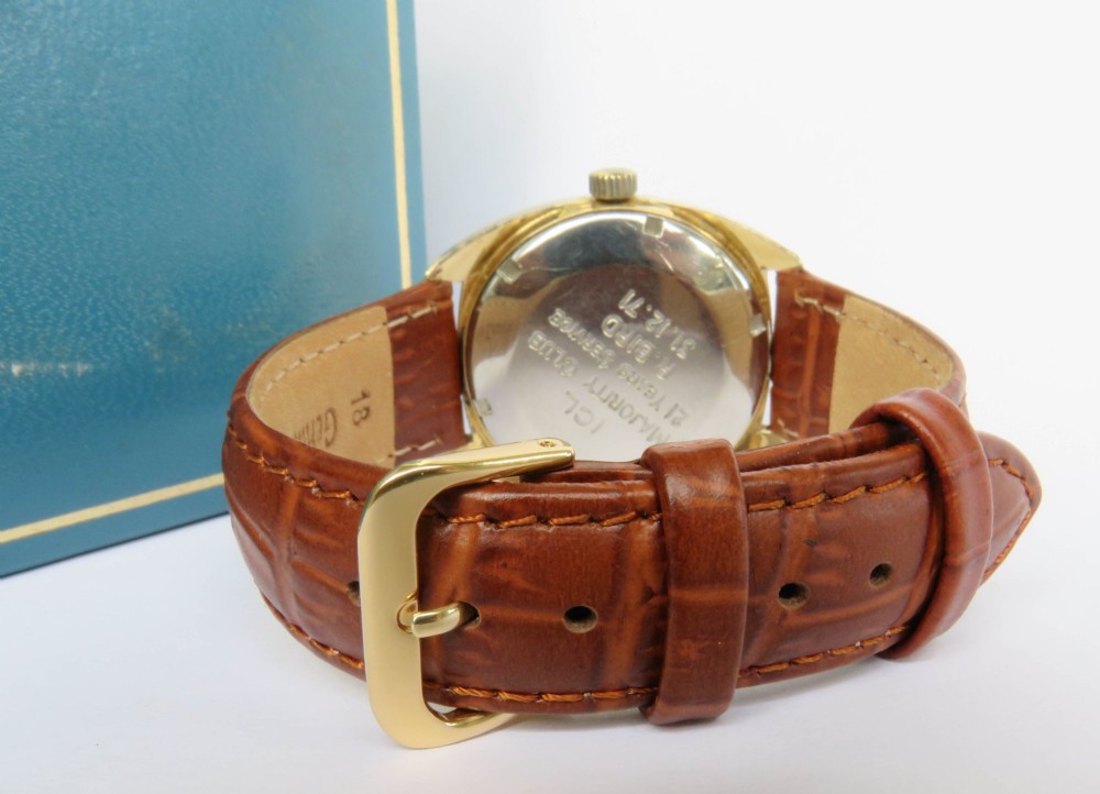 A 1969 gents Eterna-Matic 1000 wristwatch featuring a gold-toned cushion case, champagne dial with date aperture, and brown leather strap. View VI