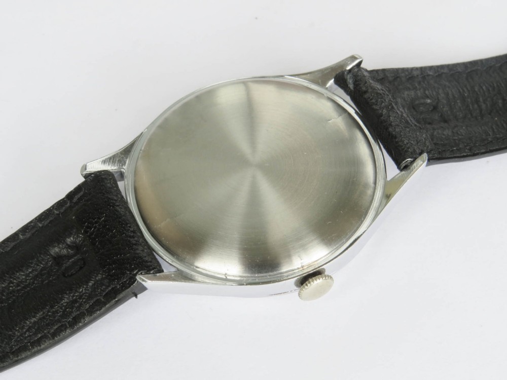A 1950s Tissot gents wristwatch featuring a cream dial with black Arabic numerals, a sub-seconds subdial at six oclock, a steel case, and a black leather strap. View IV