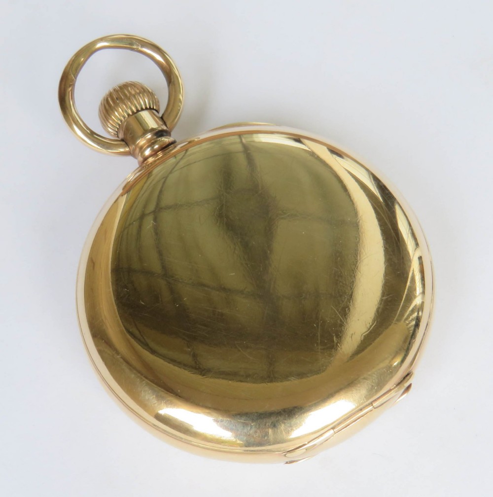 A gold open-face pocket watch featuring a white enamel dial, black Roman numerals, a sub-seconds dial, and blued steel hands. View V