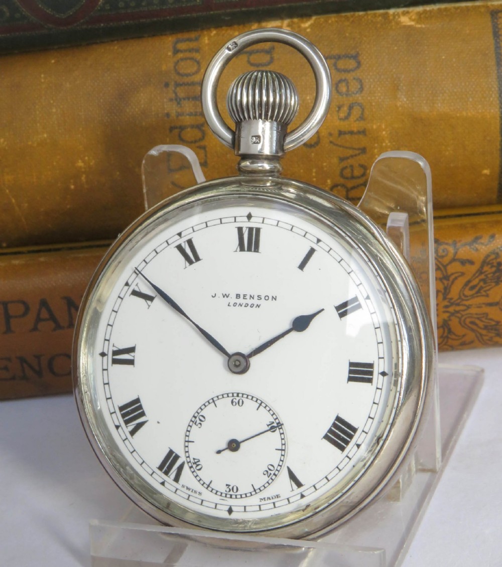 An open-face silver pocket watch featuring a white dial with black Roman numerals, a subsidiary seconds sub-dial, and a winding crown at twelve oclock.